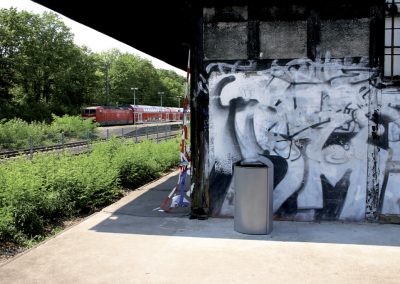 sauberer Kendo-Behälter vor einer Graffiti-Wand an einem bahnhof