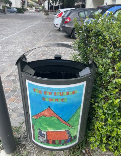 Papierkorb in Rodeneck mit einer Kinderzeichnung in der Infofläche